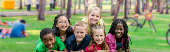 GROUP OF DIVERSE KIDS SMILING AT THE PARK