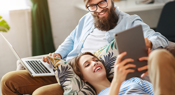 Couple looking at computer on the couch